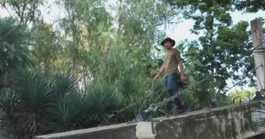 Asyalı maceracılar ormanda küçük bir dere nehrinde kameranın üzerinden atlarlar..