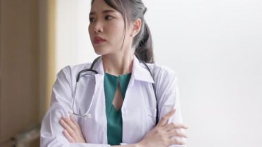 Kadın doktor, hastanenin penceresinin yanında endişeli bir şekilde bekliyor..