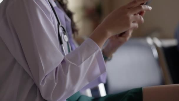 Γυναίκα Νεαρή Γιατρός Χρησιμοποιώντας Τηλέφωνό Της Ενώ Κάθεται Μια Καρέκλα — Αρχείο Βίντεο