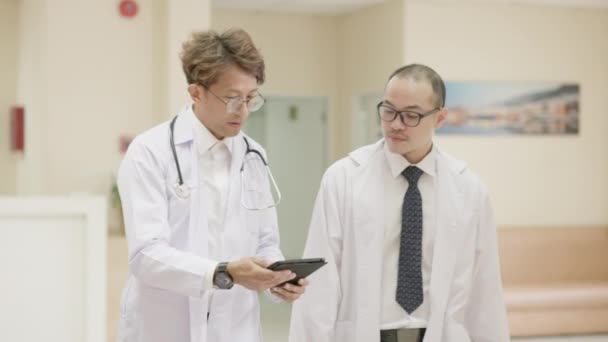 Två Manliga Läkare Vita Rockar Samtalar Använder Datortablett Och Skakar — Stockvideo