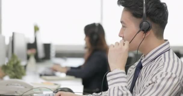 Asiático Homem Operador Telemarketing Usando Fones Ouvido Trabalhando Com Equipe — Vídeo de Stock