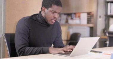 Tatmin olmuş bir Afro-Amerikalı işadamı dizüstü bilgisayarında çalışırken gülümsüyor. Ofiste Başarılı Girişimci Araştırma Yapıyor ve Notebook Slow Motion Video 'da Yazıyor