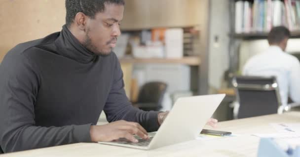 一位心满意足的非洲裔美国商人一边在笔记本电脑上工作一边笑 在办公室里 成功的企业家在笔记本慢动作视频上进行研究和打字 — 图库视频影像