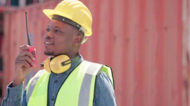 Lojistik ya da mühendislik bölümündeki ustabaşı konteyner deposunda bir telsiz ya da telsizle iş arkadaşıyla konuşuyor. Ürünün kalitesini denetleyerek kontrol etmek.