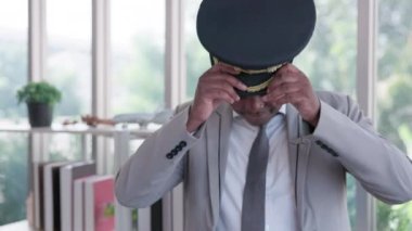 Ofiste, genç bir Afrikalı pilot şapka takıyor..