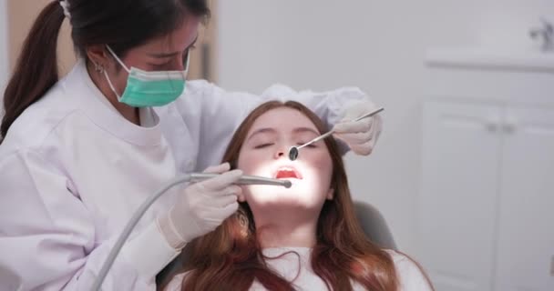 亚洲的一位女牙医检查一位女士的口腔 一个女人在诊所里接受牙科检查 — 图库视频影像