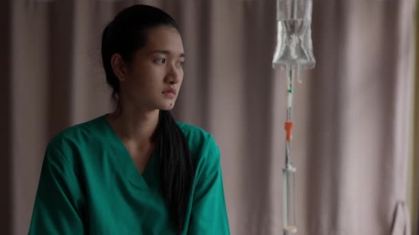 手術の前に アジアの女性患者が病院のベッドに座り 不安を感じていた 孤独の中で 女性は窓の外を見た 癌や健康問題の考え方は — ストック動画