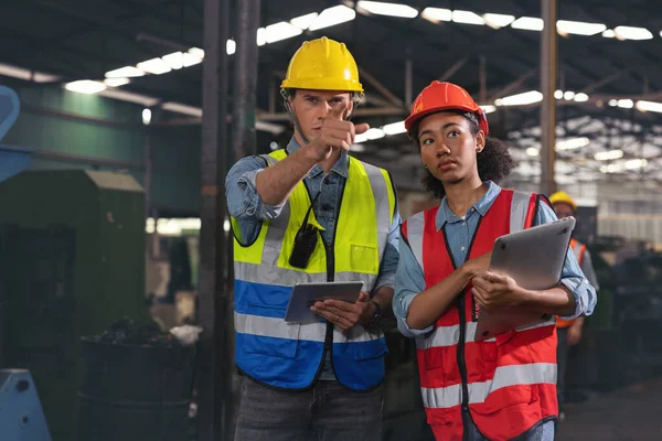 一幅与一位在工厂拿着平板电脑的工业男女工程师讨论的制造业工人的画像 一个高加索工头在监督一台数控机床 — 图库照片