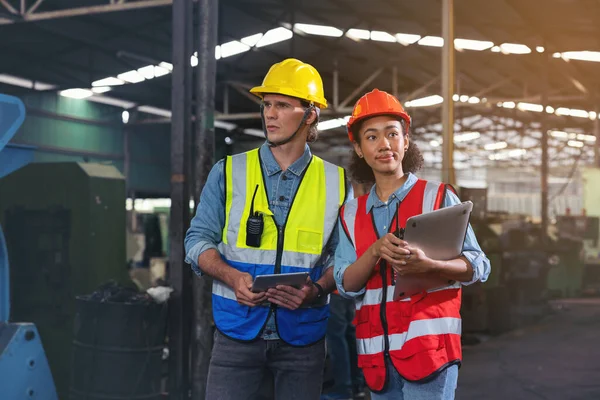 一幅与一位在工厂拿着平板电脑的工业男女工程师讨论的制造业工人的画像 一个高加索工头在监督一台数控机床 — 图库照片