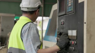 Bir imalat fabrikasında, bir endüstri mühendisi kontrol paneli işletiyor. Üretim süreci veya makine kavramı