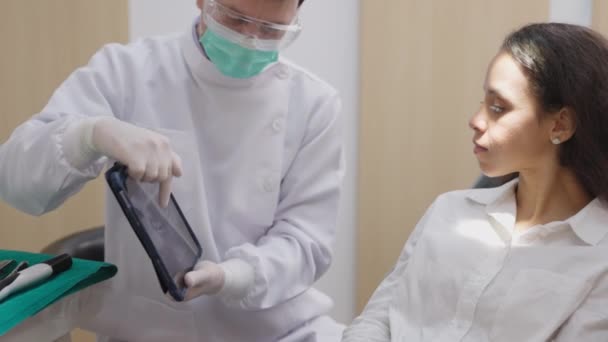 Jovem Dentista Mostra Uma Paciente Cadeira Dentária Raio Tablet Digital — Vídeo de Stock