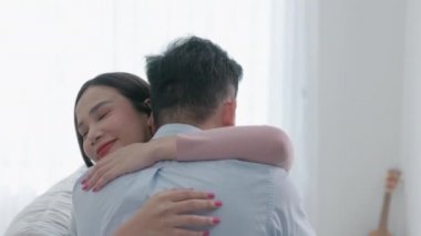 Evde, bir erkek ve bir kadın kanepede birbirlerine bağlılıklarıyla sarılıyorlar..