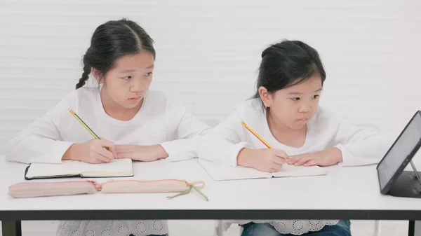 In tutorial school, Asian students learn to write in both English and Chinese.