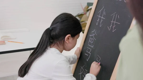 In tutorial school, Asian students learn to write in both English and Chinese.