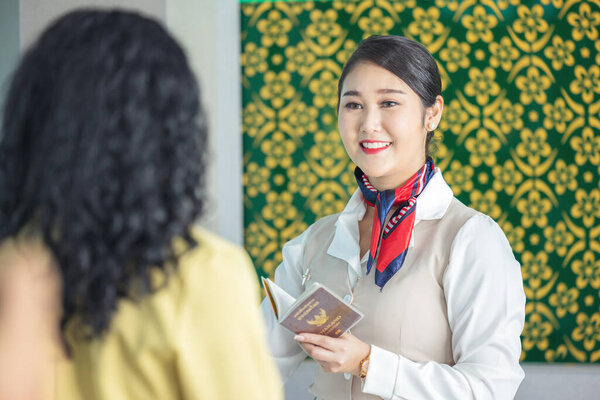 At the airport check-in counter, a passenger hands over his documents to the manager via a counter ticket.