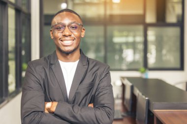 Kameraya gülümseyen siyah bir belboyun portresi..