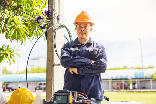 Outside, an ISP Internet Service Provider engineer stands near a fiber optic cross box.