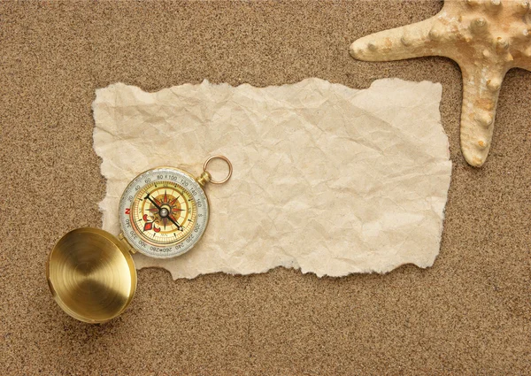 Compass on old sheet paper against the background of sand — Stock Photo, Image