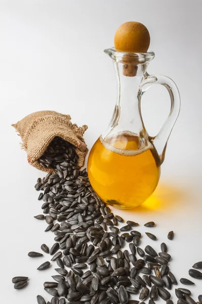 Sunflower seeds and vegetable oil in a bottle — Stock Photo, Image