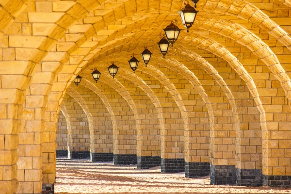 De gewelfde stenen colonnade met lantaarns — Stockfoto