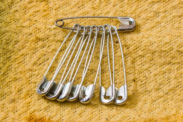 Safety pin pinned to the texture fabric — Stock Photo, Image
