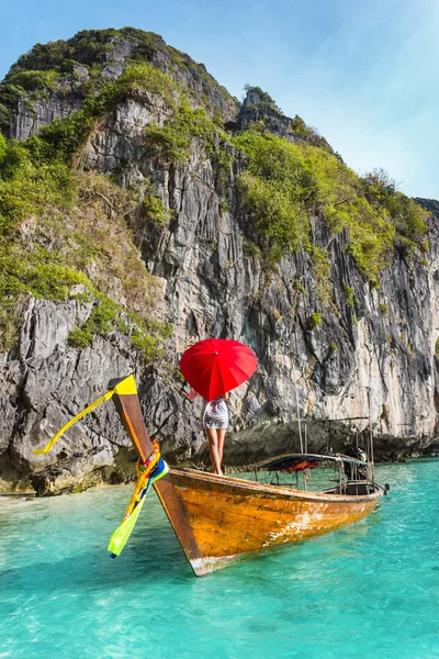 Menina com um guarda-chuva vermelho em um barco em um resort — Fotografia de Stock