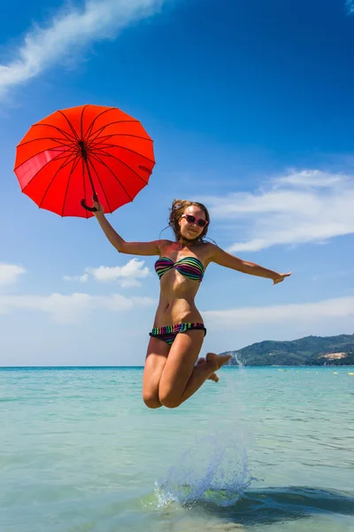 Chica con paraguas naranja en la playa en Tailandia —  Fotos de Stock