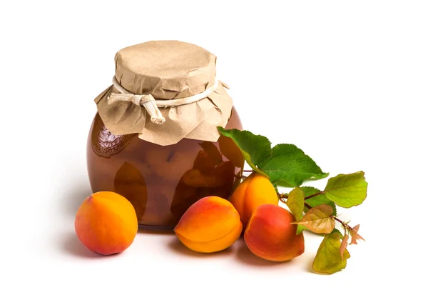 Aprikos sylt i en glasburk med mogen ljusa aprikoser på en vit — Stockfoto