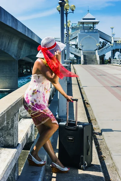 Girl in a hat with a suitcase going on rest — Stock Photo, Image