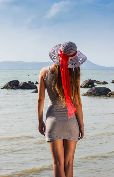 Young girl looks to the sea in the hat — Stock Photo, Image