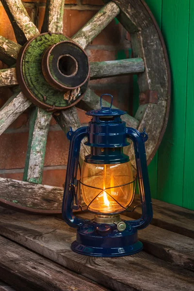 Lámpara de queroseno contra la rueda del vagón de fondo — Foto de Stock