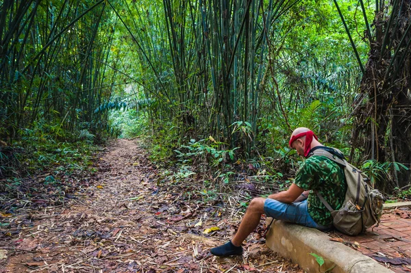 Travelling man sitting in the bamboo forest — Stock Photo, Image