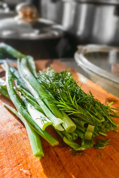 Green onions and dill on a wooden board — Stock Photo, Image