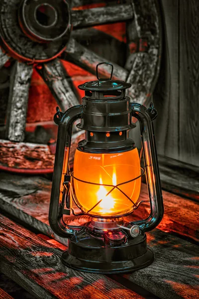 Kerosine lamp tegen de achtergrond wagon wheel — Stockfoto