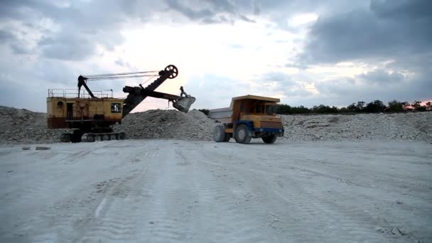 Pesado caminhão de despejo de mineração sendo carregado com minério de ferro — Vídeo de Stock