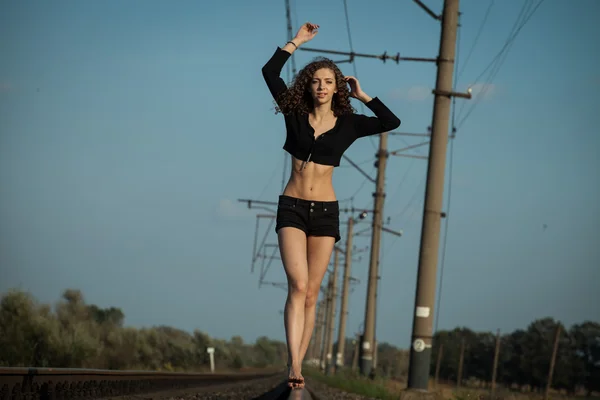 Mulher bonita esperando o trem em trilhos ferroviários — Fotografia de Stock