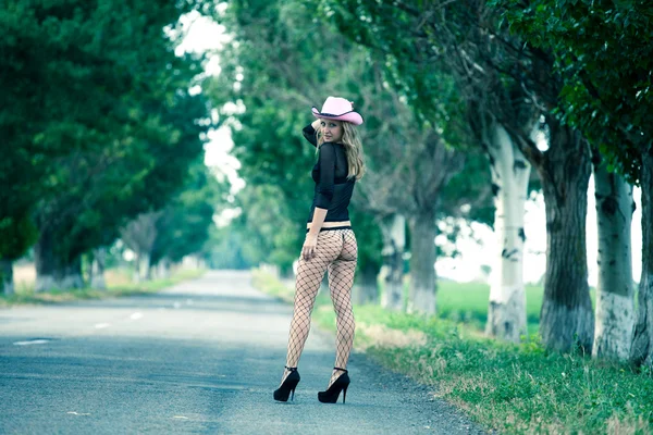 Beautiful elegant woman walking on a country road — Stock Photo, Image