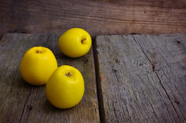 Натюрморт з жовтими яблуками на старій дошці . — стокове фото