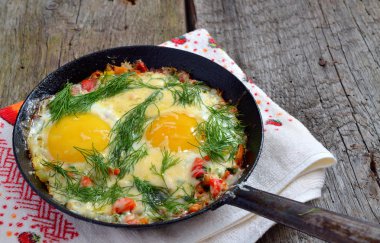 yeşillik üzerinde bir tavada kızarmış yumurta.