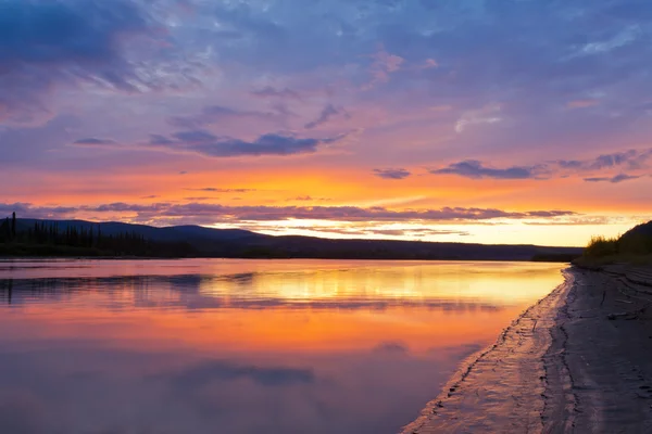 Belo pôr do sol sobre o rio Yukon perto de Dawson City — Fotografia de Stock