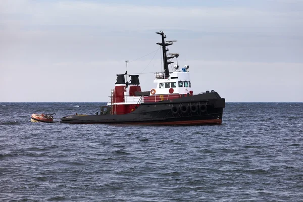 Rebocador flutuando em espera no oceano calmo na âncora — Fotografia de Stock