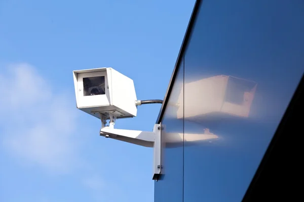 Камера видеонаблюдения на блестящем фасаде здания — стоковое фото