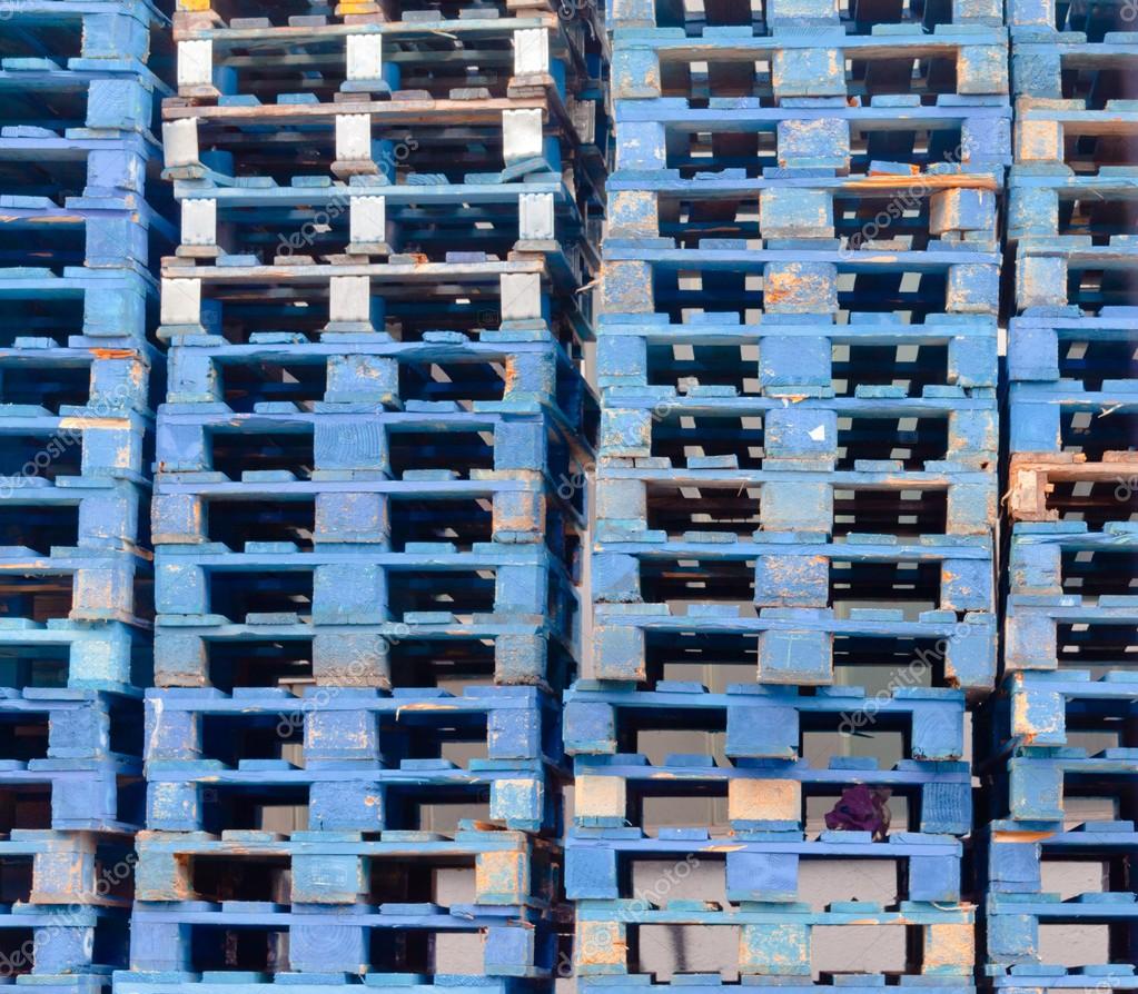 Piled blue wooden euro pallets background pattern Stock Photo by