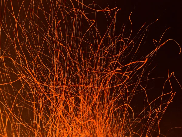 Hot orange spark trails bursting up from hell fire — Stock Photo, Image