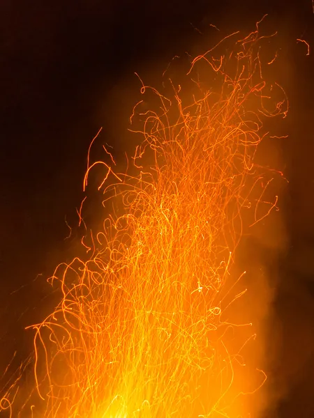 Hot orange spark trails bursting up from hell fire — Stock Photo, Image