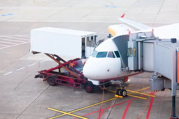 Plane on airport docked for boarding and service — Stock Photo, Image