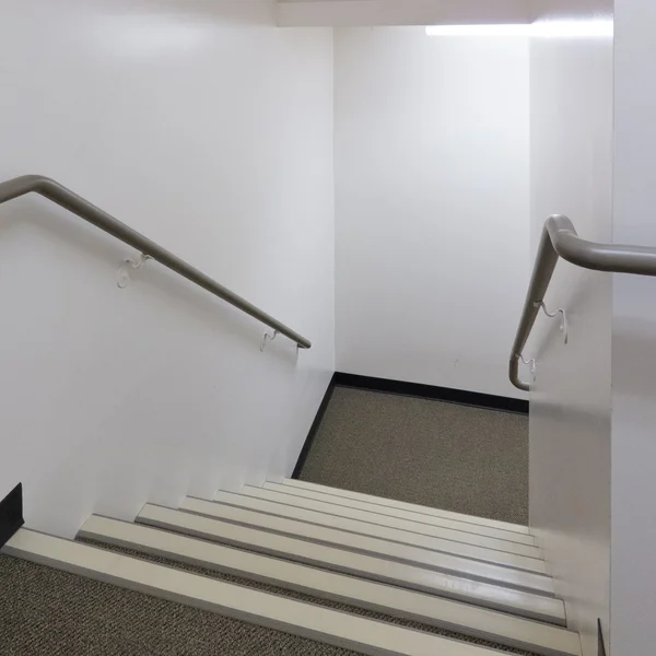 Vue sur un escalier bien éclairé avec des mains courantes — Photo