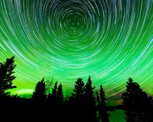 Star trails around Polaris and Northern lights — Stock Photo, Image