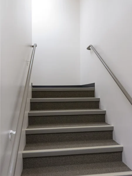 Recherche d'un escalier bien éclairé avec des mains courantes — Photo