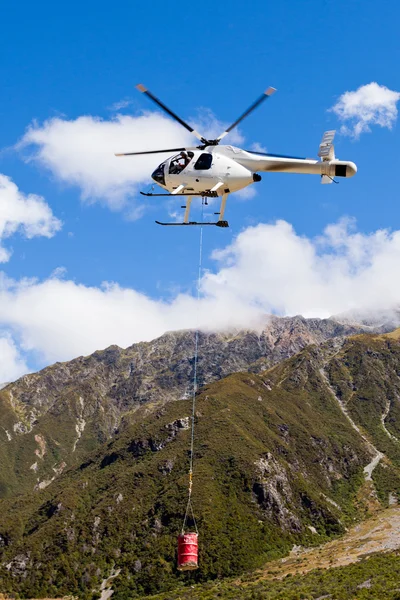 เฮลิคอปเตอร์ขนส่งบินเหนือถิ่นทุรกันดารภูเขา — ภาพถ่ายสต็อก